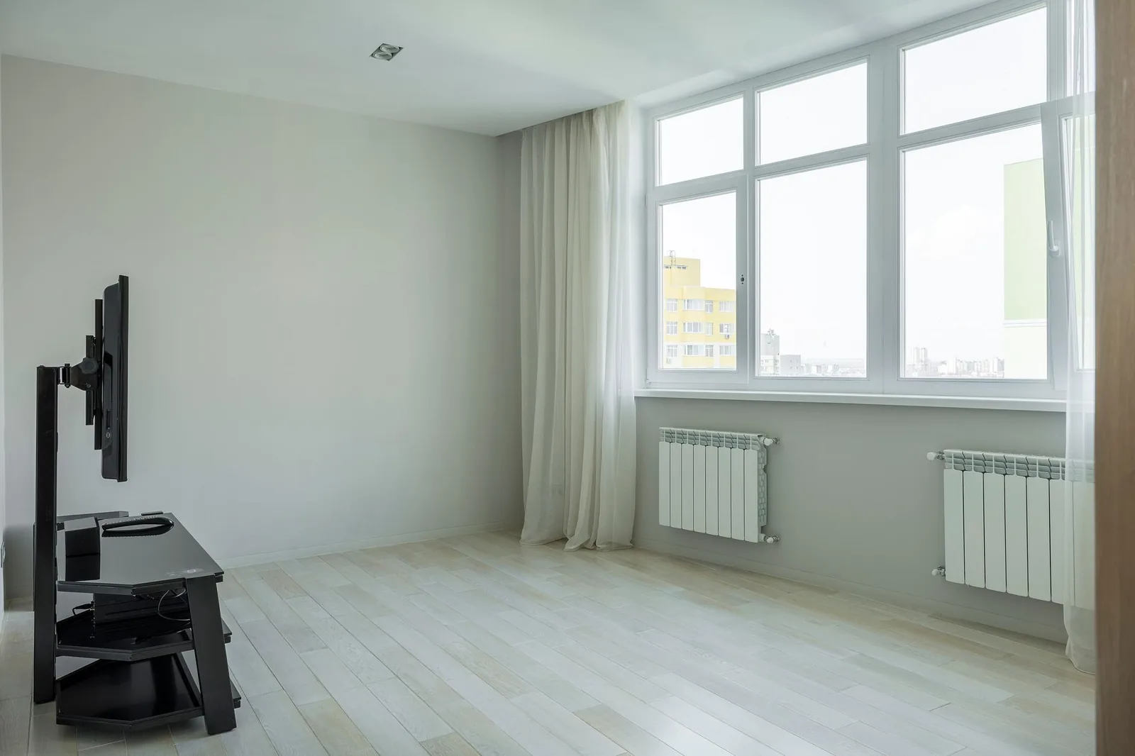 Moderner Flachheizkörper unter einem Fenster in einem Wohnraum