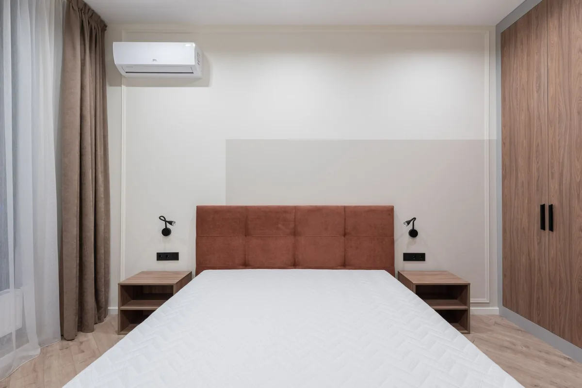 Klimagerät an der Wand über einem Bett in einem Schlafzimmer