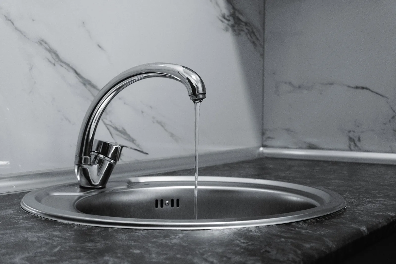 Küchenarmatur über einer Spüle mit fließendem Wasser