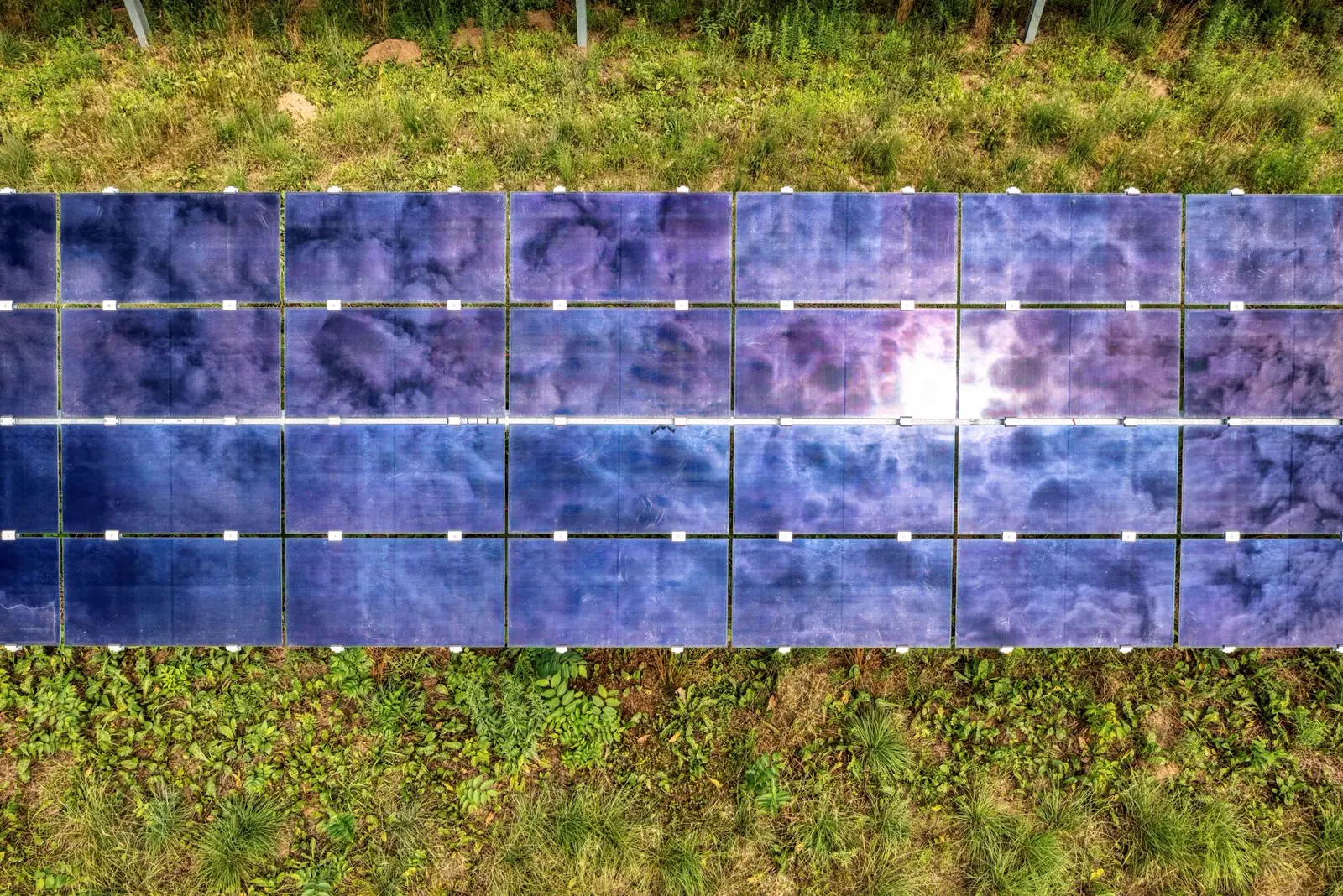 Photovoltaikanlage im Sonnenlicht neben einem Wohnhaus